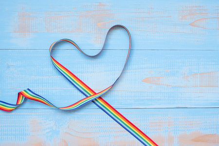 LGBTQ with heart shape Rainbow ribbon on blue pastel wooden background for Lesbian, Gay, Bisexual, Transgender and Queer communityの写真素材