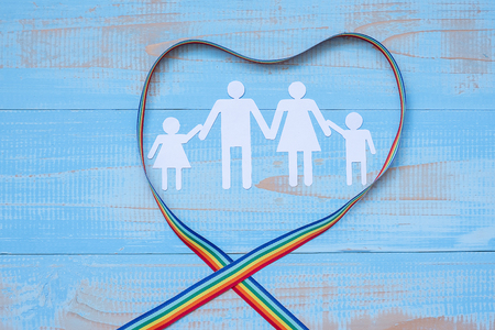 people paper shape with LGBTQ heart shape Rainbow ribbon on blue pastel wooden background for Lesbian, Gay, Bisexual, Transgender and Queer communityの写真素材
