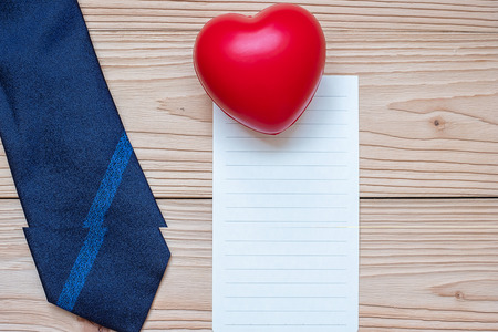 empty card with blue necktie and red heart shape on wooden background with copy space for text. Happy Father's Day and International Men's Day conceptsの写真素材