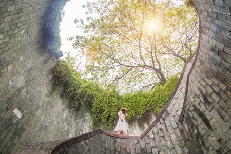 Young Woman tourist traveling and standing on underground spiral staircase at  Parkの写真素材