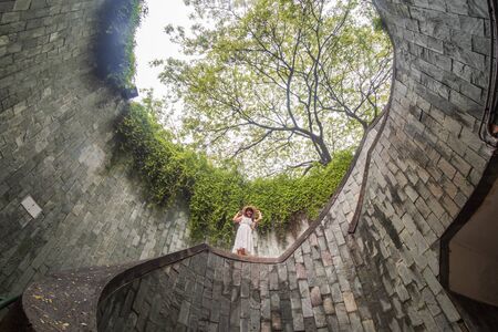 Young Woman tourist traveling and standing on underground spiral staircase at Parkの写真素材