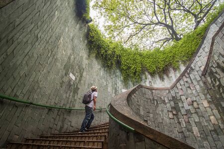 young man tourist traveling and standing on underground spiral staircase at Parkの写真素材