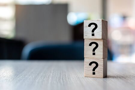 Businessman hand holding Questions Mark word with wooden cube block.の写真素材