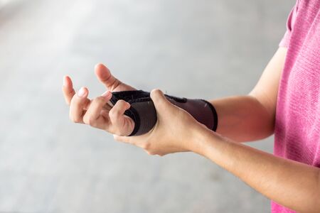 Young woman holding her wrist pain because using computer long time.  Disease and healthcare conceptの写真素材