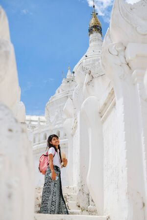 young woman traveling with bag visit Hsinbyume Pagoda (Mya Thein Dan) or called white Taj Mahal of Irrawaddy river, located in Mingun, Sagaing region near Mandalay, Myanmar. landmark and popularの写真素材
