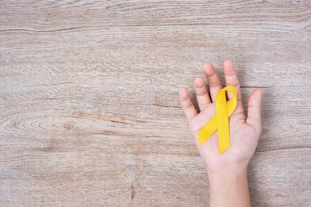 Suicide prevention and Childhood Cancer Awareness, Yellow Ribbon for supporting people living and illness. children Healthcare and World cancer day conceptの写真素材