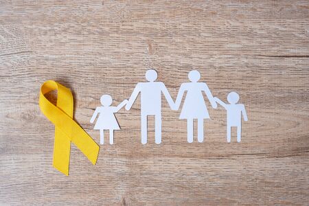 Suicide prevention and Childhood Cancer Awareness, Yellow Ribbon and family paper shape for supporting people living and illness. children Healthcare and World cancer day conceptの写真素材
