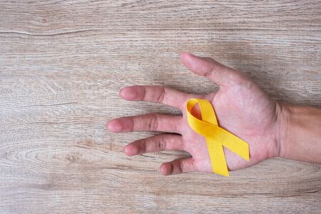 Suicide prevention and Childhood Cancer Awareness, Yellow Ribbon for supporting people living and illness. children Healthcare and World cancer day conceptの写真素材