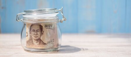 1000 Thai Baht banknote in glass jar. Money, business, investment, retirement planning, finance and world Saving day conceptsの写真素材