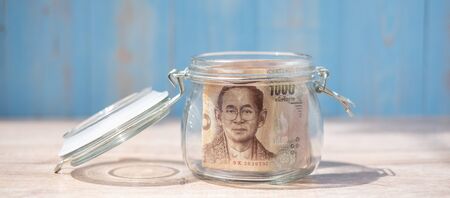 1000 Thai Baht banknote in glass jar. Money, business, investment, retirement planning, finance and world Saving day conceptsの写真素材