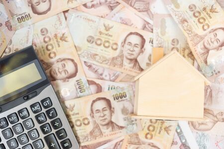 Wood house model, calculator and money, Thai baht banknote. real estate, Property investment, home mortgage financial and savings conceptsの写真素材