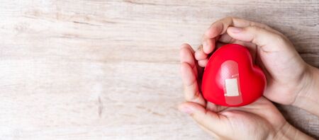 Woman holding Red heart shape on wooden background. Healthcare, life Insurance and World Heart Day...