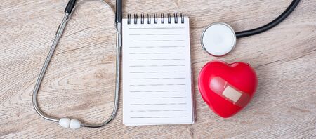 Blank notebook, Stethoscope with Red heart shape on wooden background. Healthcare, life Insurance...