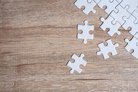 puzzle pieces on wood table background. Business solutions, mission target, successful, goals, cooperation, partnership and strategy conceptの写真素材