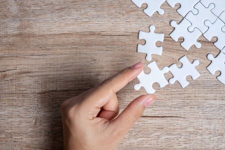 Businessman hand connecting  puzzle piece. Business solutions, mission target, successful, goals, cooperation, partnership and strategy conceptの写真素材