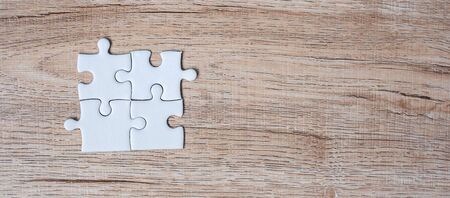 puzzle pieces on wood table background. Business solutions, mission target, successful, goals, cooperation, partnership and strategy conceptの写真素材