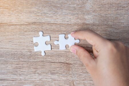 Businessman hand connecting couple puzzle piece. Business solutions, mission target, successful, goals, cooperation, partnership and strategy conceptの写真素材