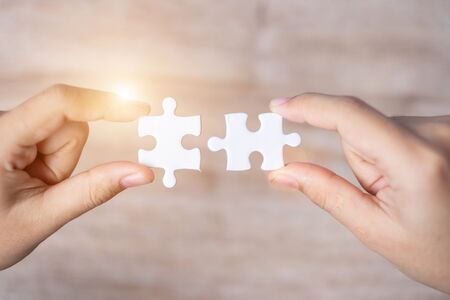 Businessman hand connecting couple puzzle piece. Business solutions, mission target, successful, goals, cooperation, partnership and strategy conceptの写真素材