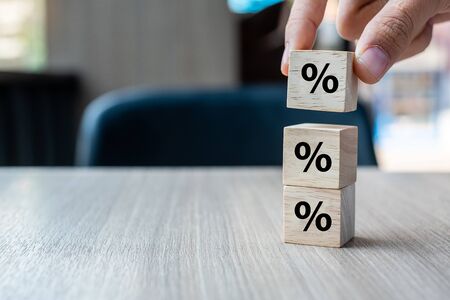 businessman Hand putting wood cube block with percentage symbol icon. Interest rate,  financial, ranking and mortgage rates conceptの写真素材