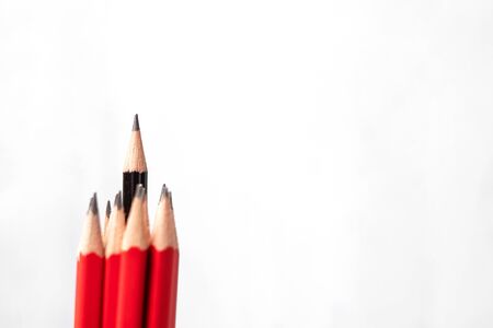 Black pencil different from crowd of red pencils. Unique Leader, strategy, independence, think different, business and success conceptの写真素材