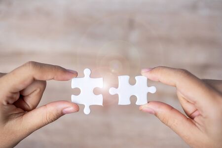 Businessman hand connecting couple puzzle piece. Business solutions, mission target, successful, goals, cooperation, partnership and strategy conceptの写真素材