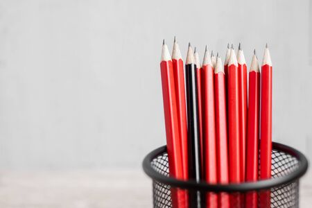 Black pencil different from crowd of red pencils. Unique Leader, strategy, independence, think different, business and success conceptの写真素材