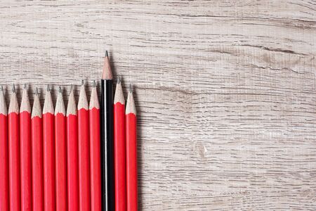Black pencil different from crowd of red pencils. Unique Leader, strategy, independence, think different, business and success conceptの写真素材
