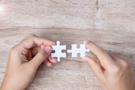 Businessman hand connecting couple puzzle piece. Business solutions, mission target, successful, goals, cooperation, partnership and strategy conceptの写真素材