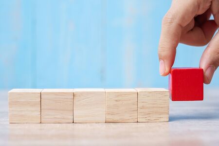 Businessman hand placing or pulling Red wooden block on the building. Business planning, Risk Management, Solution, strategy, different and Unique Conceptsの写真素材