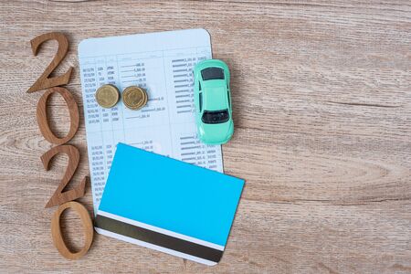 2020 Happy New Year with Book bank and Car on wood table background with copy space. financial, money, refinance, Car for cash and Car insurance conceptの写真素材