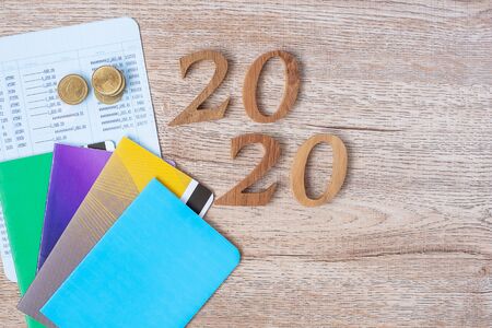 2020 Happy New Year with book bank and coins on wood table background with copy space. banking,...