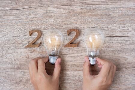 2020 Happy New year with Businessman holding lightbulb with crumbled paper and wooden number on table. New Start, Idea, Creative, Innovation, Resolution, Solution, Strategy, Goals and Mission conceptの写真素材