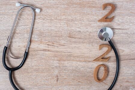 2020 Happy New Year for healthcare, Wellness and medical concept. Stethoscope with red heart and wooden number on table backgroundの写真素材