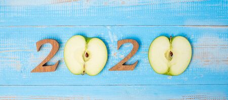 2020 Happy New Year and New You with green apple on blue wood background. Goals, Healthy, Healthcare, Resolution, Time to New Start, sport, fitness and dieting concept.の写真素材