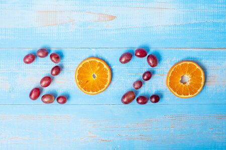2020 Happy New Year and New You with Orange fruit on blue wood background. Goals, Healthy, Healthcare, Resolution, Time to New Start, sport, fitness and dieting concept.の写真素材