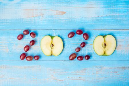 2020 Happy New Year and New You with green apple on blue wood background. Goals, Healthy, Healthcare, Resolution, Time to New Start, sport, fitness and dieting concept.の写真素材