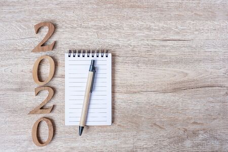 2020 Happy New years with paper notebook, pen and wooden number on table for copy space. New Start, Resolution, Goals and Mission Conceptの写真素材