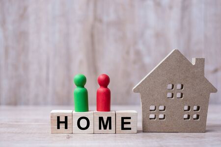 Wood block with HOME text and house model on wooden background. Banking, real estate, Property investment, home mortgage, financial and savings conceptsの写真素材