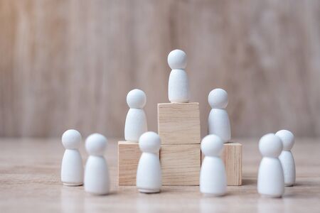 hand holding top of businessman leader with crowd of wooden men. leadership, business, team, teamwork and Human resource management conceptの写真素材