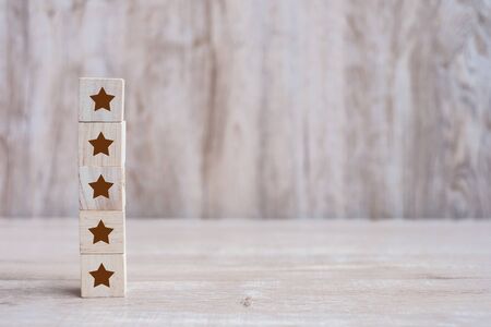 wooden blocks with the five star symbol. Customer reviews, feedback, rating, ranking and service concept.の写真素材