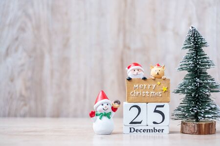 25 December calendar with Christmas decoration, snowman, Santa claus and pine tree  on wooden table background, preparation for holiday, Happy New Year and Xmas Conceptの写真素材