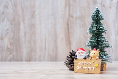 Christmas decoration, snowman, Santa claus and pine tree  on wooden table background, preparation for holiday, Happy New Year and Xmas Conceptの写真素材