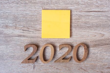 2020 Happy New years with yellow paper note and wooden number on table for copy space. New Start, Resolution, Goals and Mission Conceptの写真素材