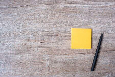 blank yellow note with pen on wooden table background. Strategy, mission, vision and Goal conceptの写真素材