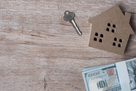 2020 Happy New Year with house model and money on wooden background. Banking, real estate, investment, financial, savings and New Year Resolution conceptsの写真素材