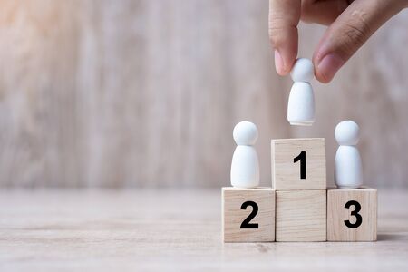 hand pulling Man wooden top of state or the winner. People, Business, Successful and Victory Conceptsの写真素材