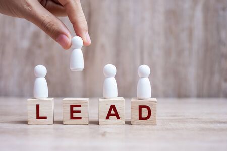 hand holding businessman over block building with LEAD text. leadership, business, team, teamwork and Human resource management conceptの写真素材