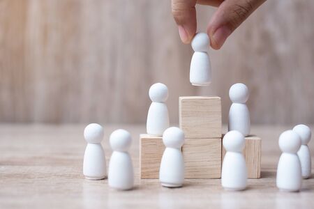 hand holding top of businessman leader with crowd of wooden men. leadership, business, team, teamwork and Human resource management conceptの写真素材