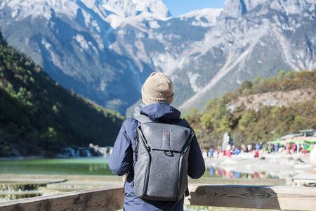 Young man traveler traveling at Blue Moon Valley, landmark and popular spot inside the Jade Dragon Snow Mountain Scenic Area, near Lijiang Old Town. Lijiang, Yunnan, China. Solo travel conceptの写真素材