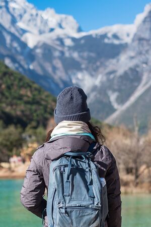 Young woman traveler traveling at Blue Moon Valley, landmark and popular spot inside the Jade Dragon Snow Mountain Scenic Area, near Lijiang Old Town. Lijiang, Yunnan, China. Solo travel conceptの写真素材